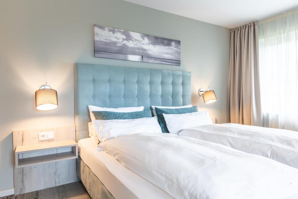 UtersumWaastwinj - 500m vom Strand的一间卧室设有两张床和蓝色床头板