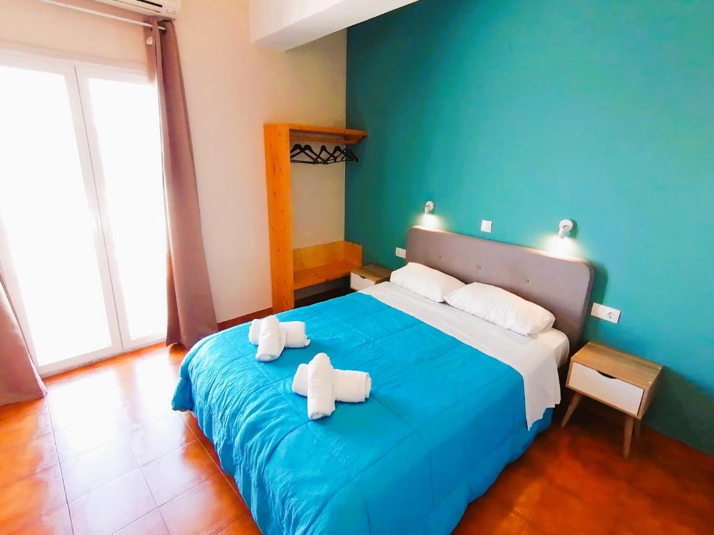 派尔季卡Perdika Mare Guesthouse的一间卧室配有蓝色的床和毛巾
