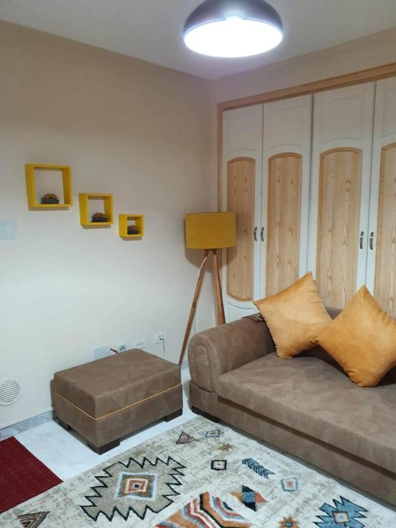 斯法克斯Appartement confortable - Sfax centre的带沙发和搁脚凳的客厅
