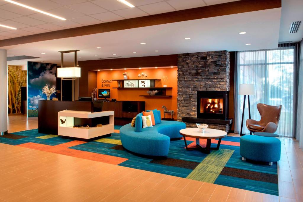 阿默斯特Fairfield Inn & Suites by Marriott Buffalo Amherst/University的客厅设有壁炉和蓝色椅子