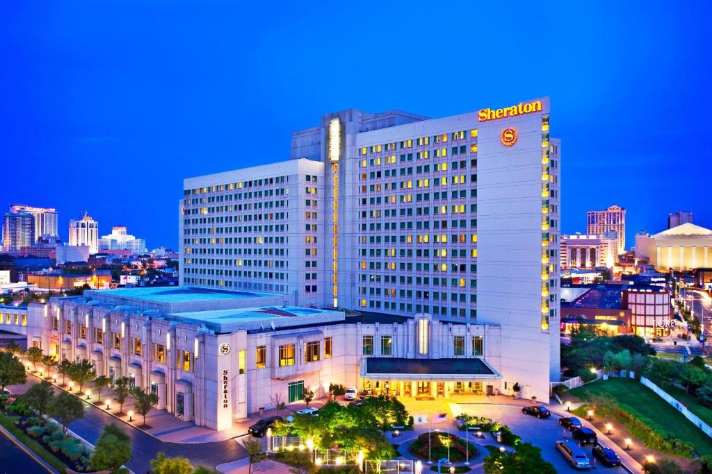 大西洋城大西洋城会议中心喜来登酒店的一座白色的大建筑,晚上有时钟