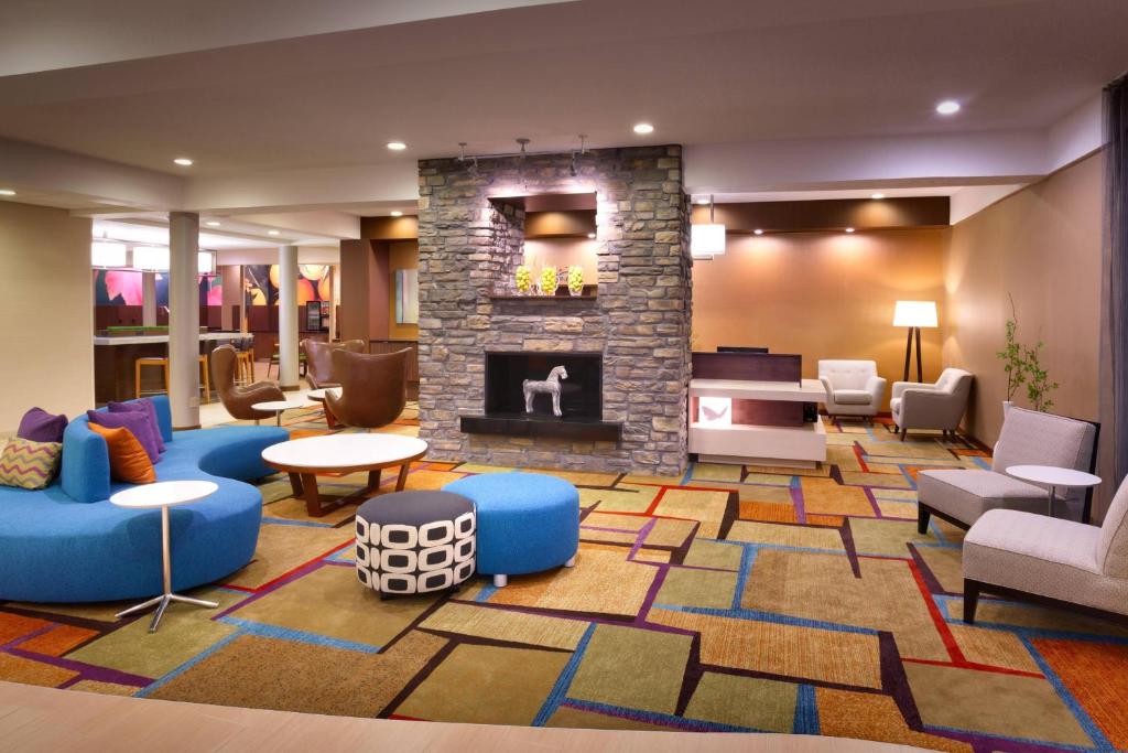 盐湖城盐湖城市中心费尔菲尔德酒店及套房的大堂设有壁炉、沙发和椅子