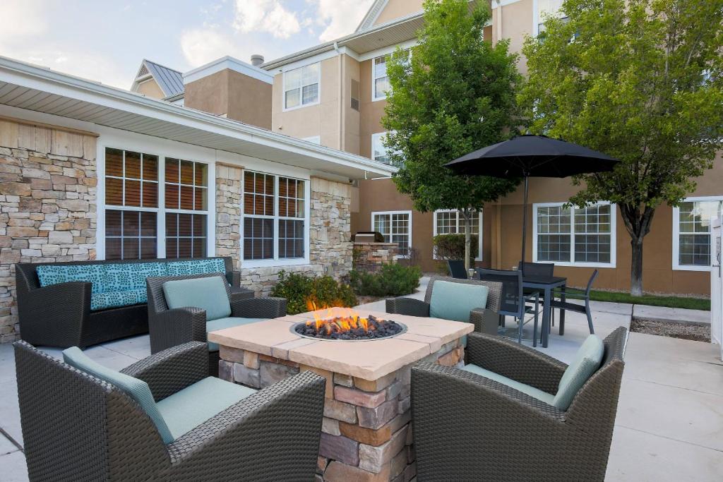 阿尔伯克基Residence Inn by Marriott Albuquerque North的庭院配有桌椅和遮阳伞。