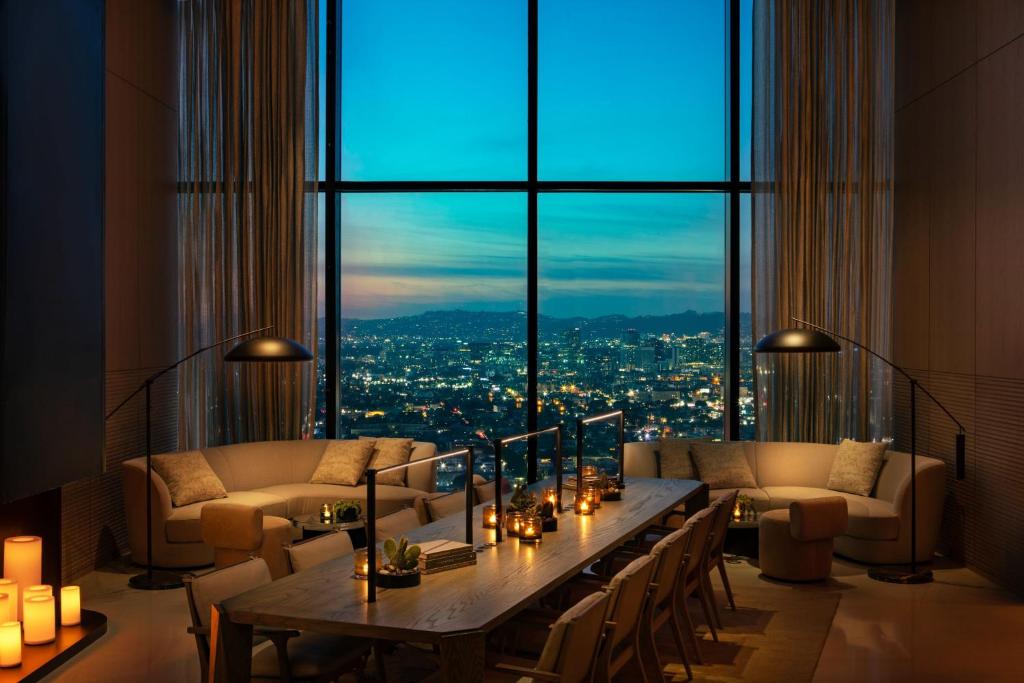 洛杉矶AC Hotel by Marriott Downtown Los Angeles的客厅设有桌子和大窗户