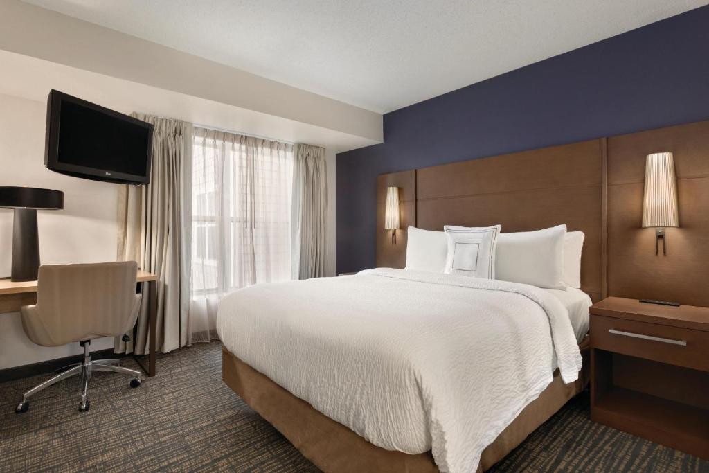 奇克托瓦加Residence Inn by Marriott Buffalo Galleria Mall的酒店客房设有一张大床和一张书桌。