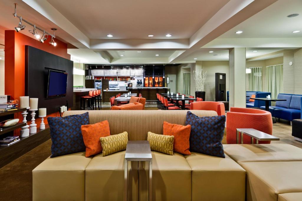 哈蒙德芝加哥东南/印第安纳哈蒙德万怡酒店的客厅配有带橙色和蓝色枕头的沙发