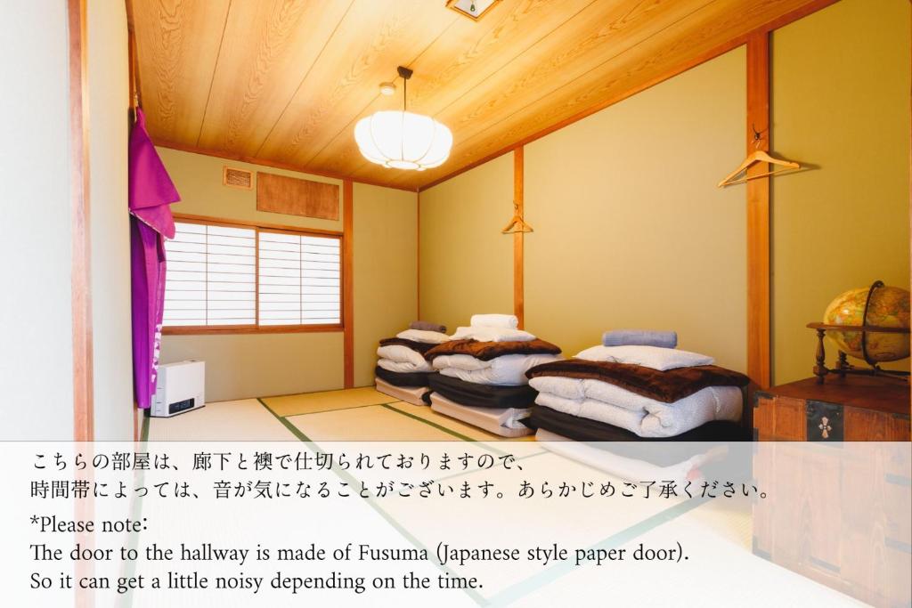松本Couch Potato Hostel - Vacation STAY 88241的墙上写着书的客房内的两张床