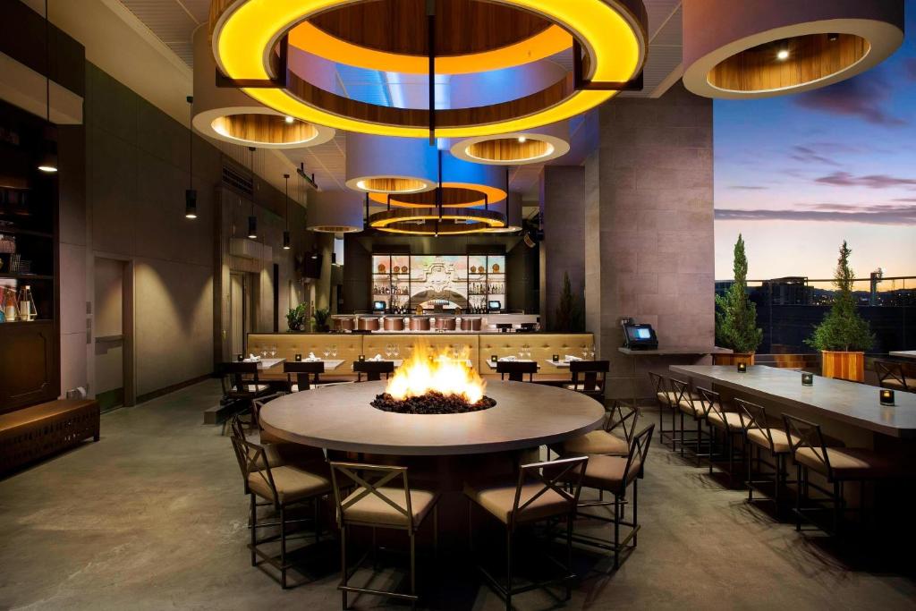 圣地亚哥圣地亚哥煤气灯区万怡酒店/会议中心的餐厅设有火坑和桌椅