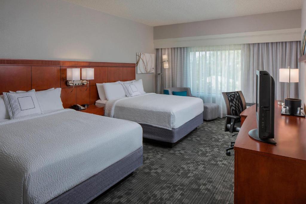 奥兰多奥兰多国际大道万怡酒店/会议中心的酒店客房设有两张床和一张书桌及电视