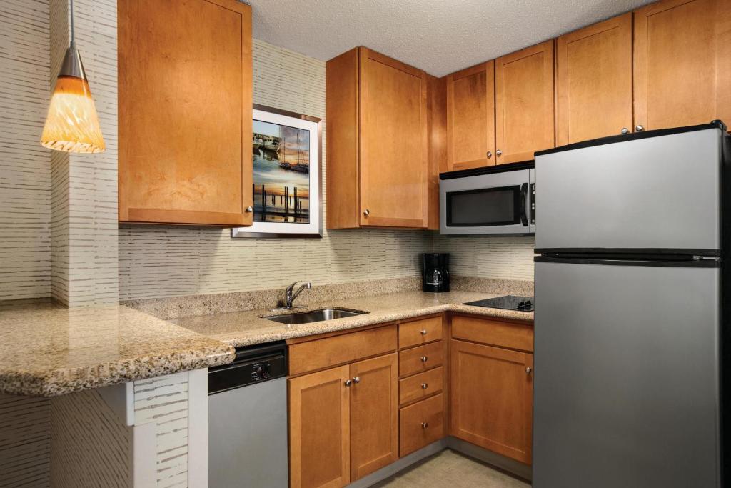 米德尔敦Residence Inn by Marriott Newport Middletown的厨房配有木制橱柜和冰箱。