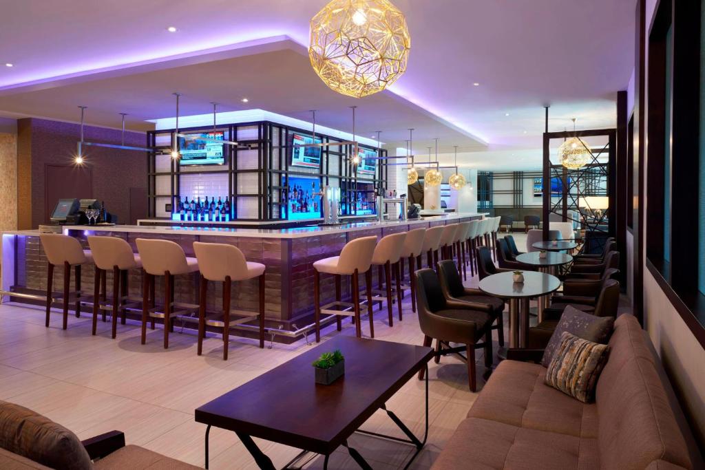 多伦多多伦多机场万豪酒店的餐厅设有酒吧,配有桌椅