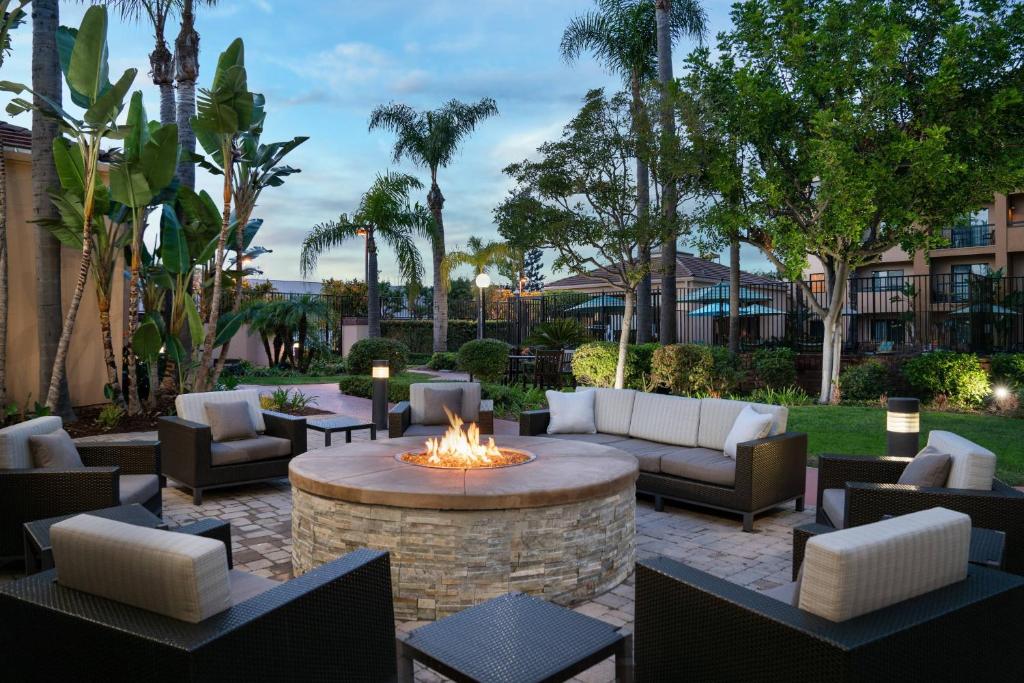 圣安娜梅萨海岸南海岸新城万怡酒店的庭院设有火坑、沙发和椅子