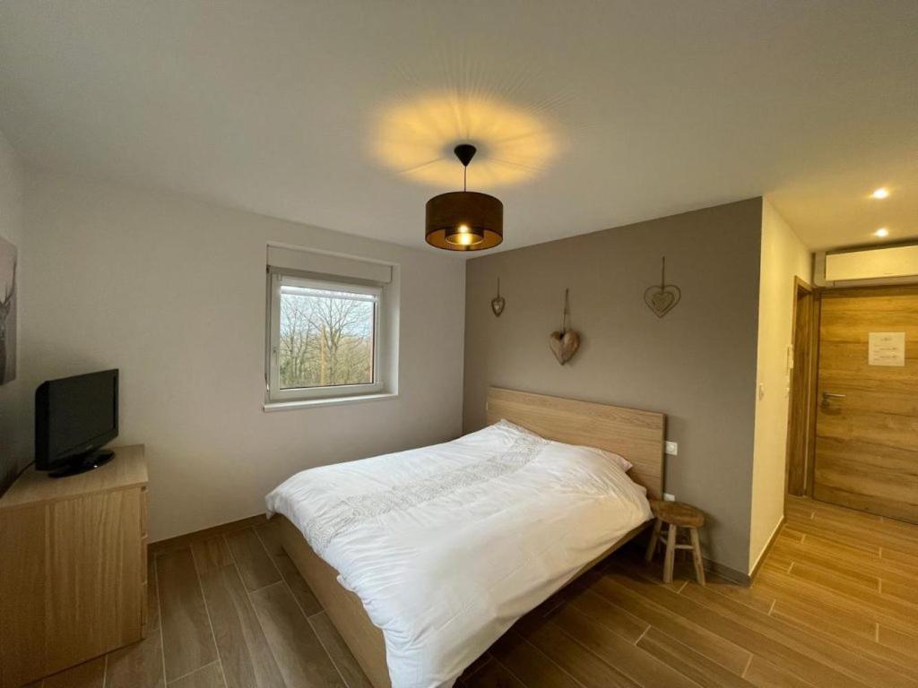 BernardswillerLa Perle d'Alsace的卧室配有白色的床和电视。