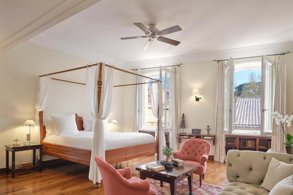圣特罗佩Airelles Pan Dei Palais的一间带天蓬床的卧室和一间客厅