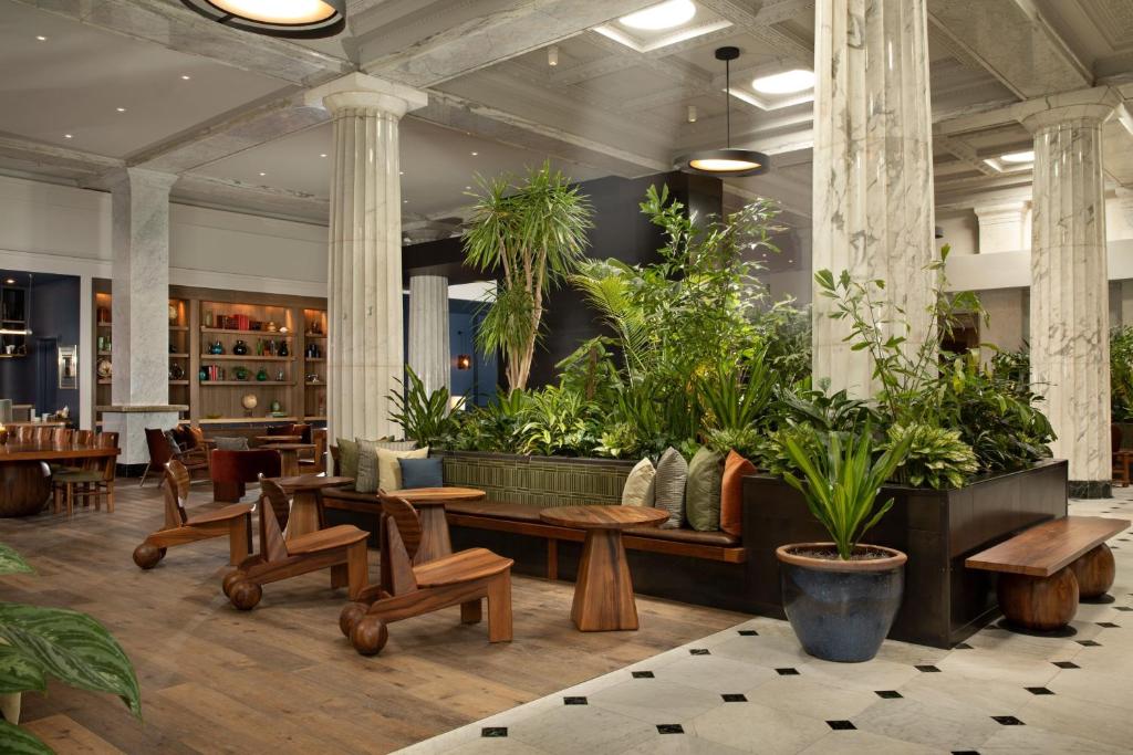 明尼阿波利斯Emery Hotel, Autograph Collection的大堂设有桌子和盆栽植物