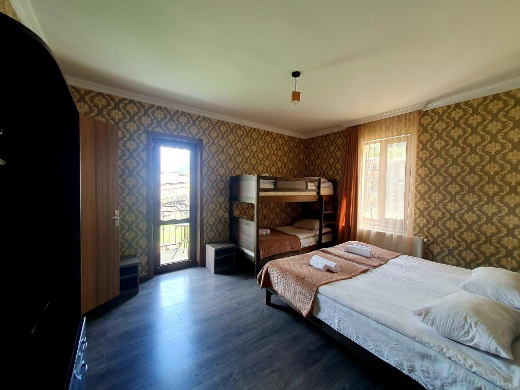 卡兹贝吉Nikolo Inn的一间卧室设有一张大床和一个窗户。