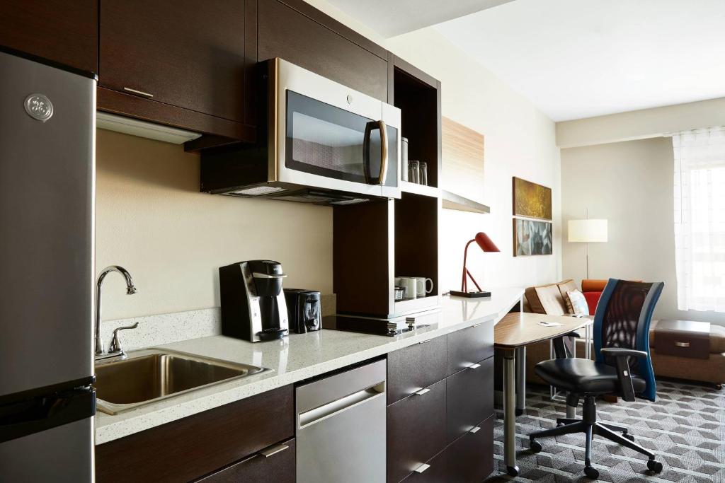奥法伦TownePlace Suites by Marriott St. Louis O'Fallon的一个带水槽和桌子的厨房