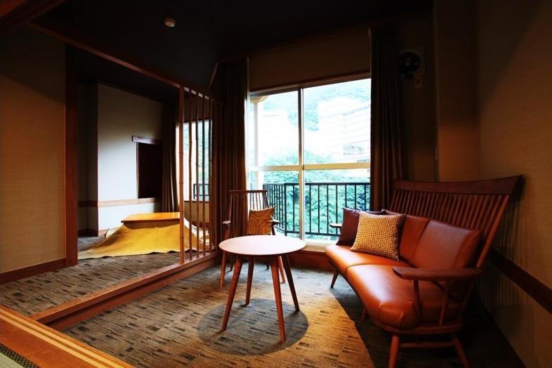 日光白河汤之藏酒店的客房设有桌子、椅子和窗户。