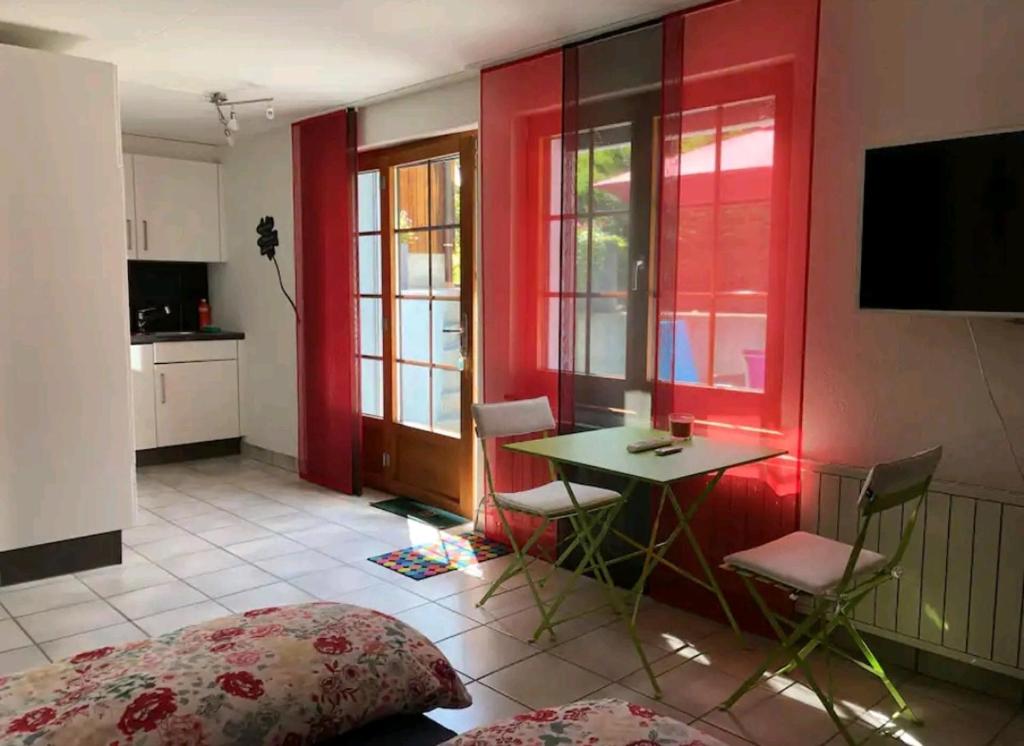 CourrendlinStudio à Courrendlin的配有桌椅和红色墙壁的房间