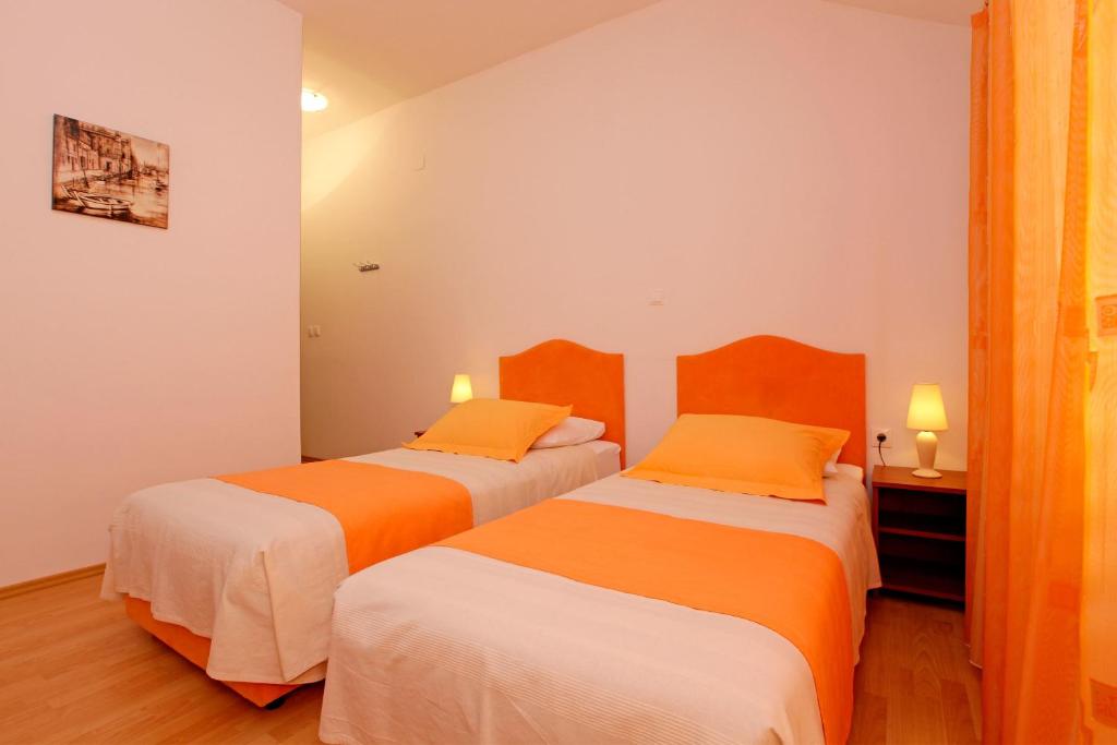 尼亚卢卡Guest House Kod Peskarije的橙色和白色的客房内的两张床