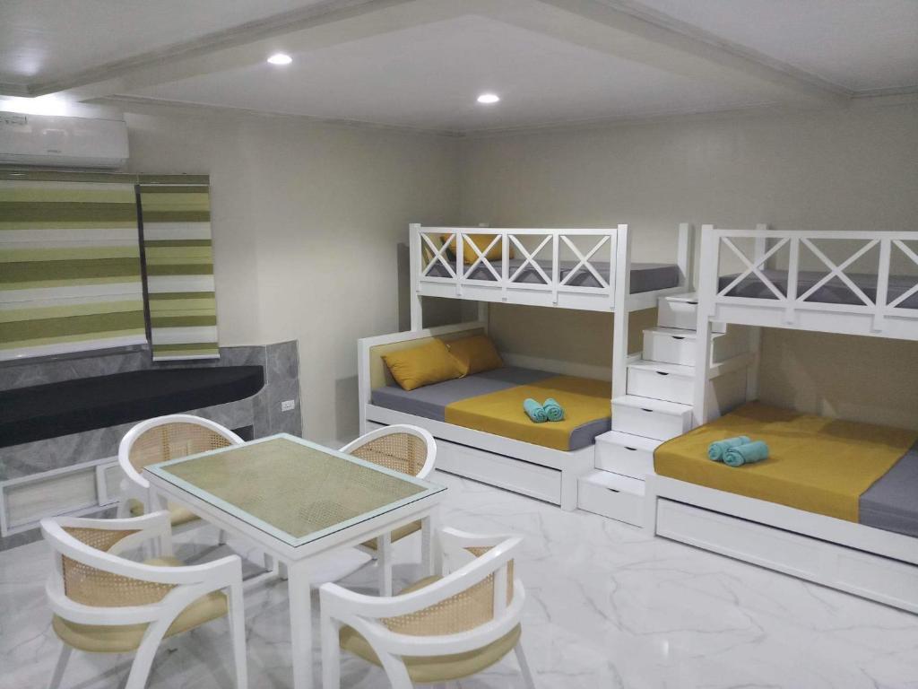 BolinaoMichaels Homestay - Farm Villa nr Patar Beach & Bolinao Falls的客房设有双层床和桌椅。