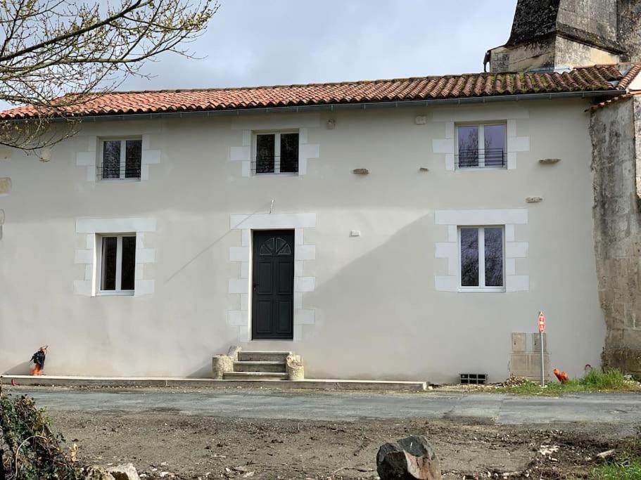 ChampdolentP’tit Gîte du prieuré的街上有一扇黑门的白色房子