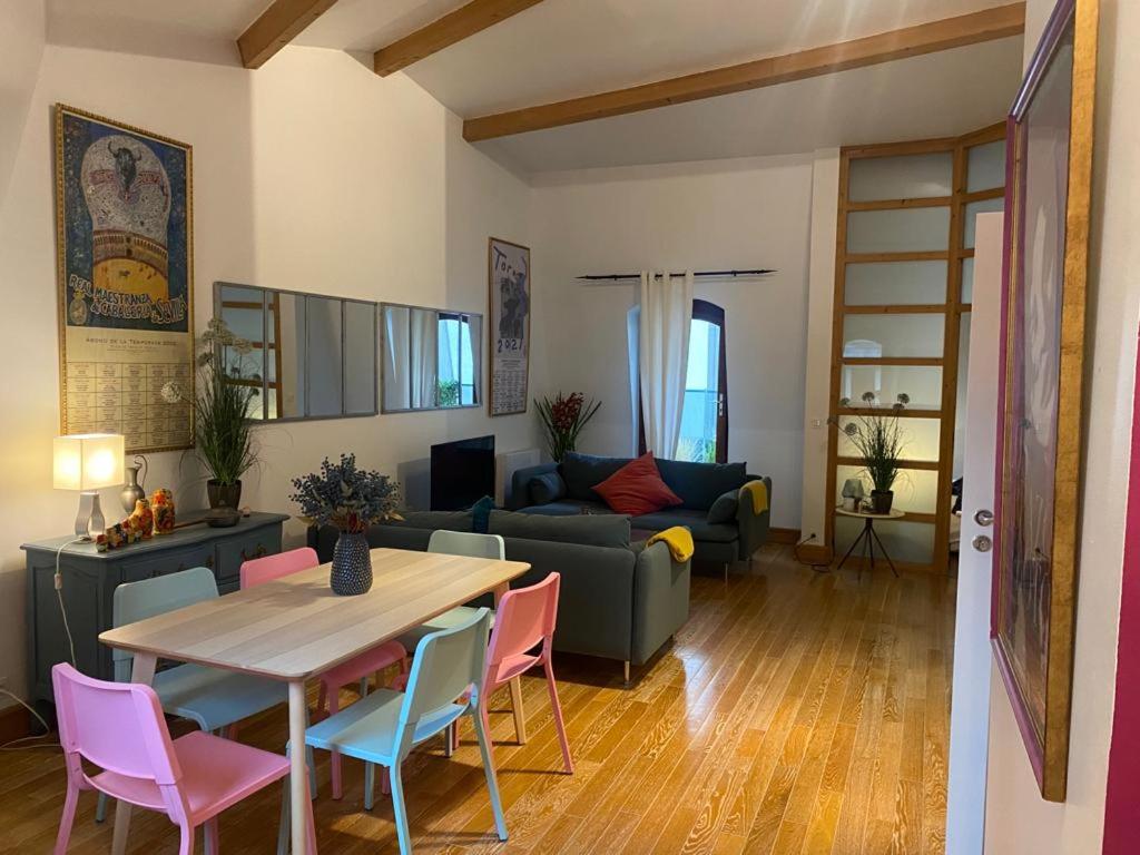莱克朗兰比塞特尔Superbe et accuiellent appartement的客厅配有桌子和粉红色椅子