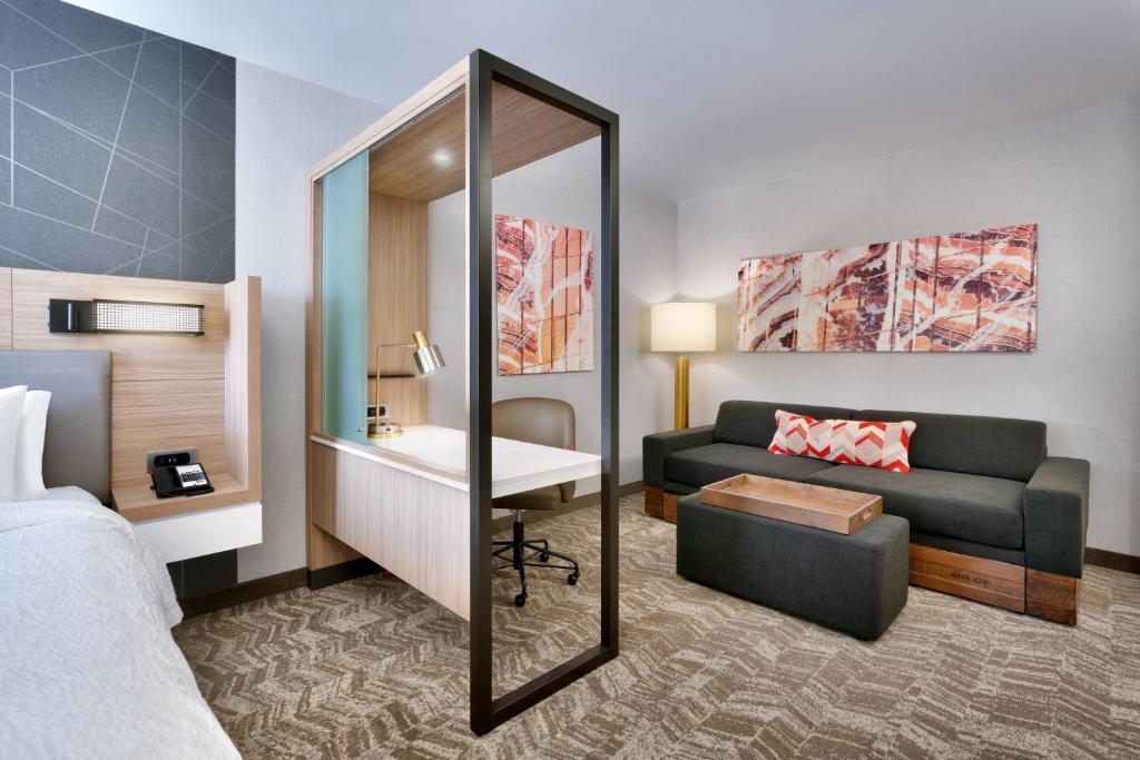 盐湖城SpringHill Suites by Marriott Salt Lake City Sugar House的酒店客房配有床、沙发和镜子