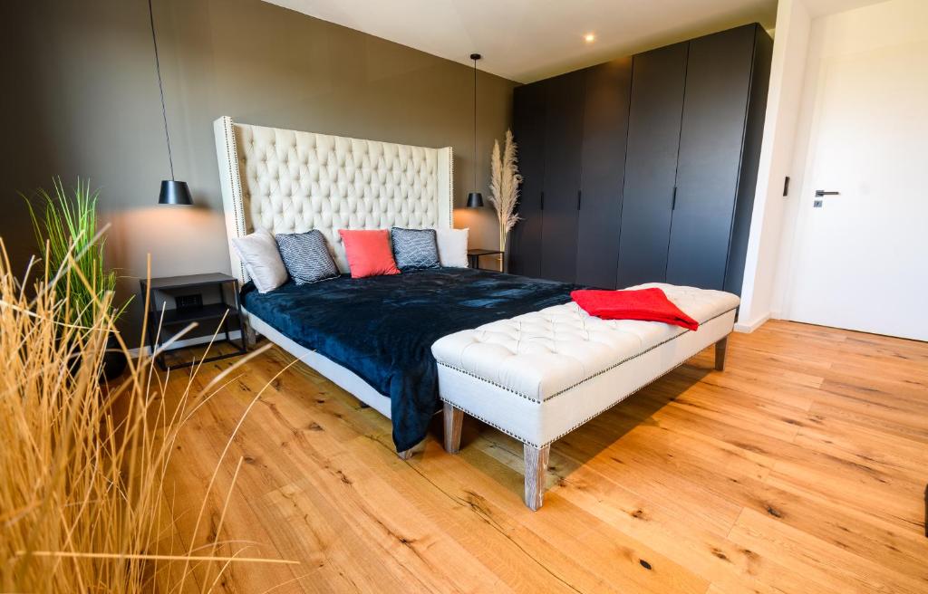 基姆湖畔普林OrangeHome Design Apartment zwischen See & Zentrum的一间卧室配有一张特大号床,提供蓝色和红色枕头