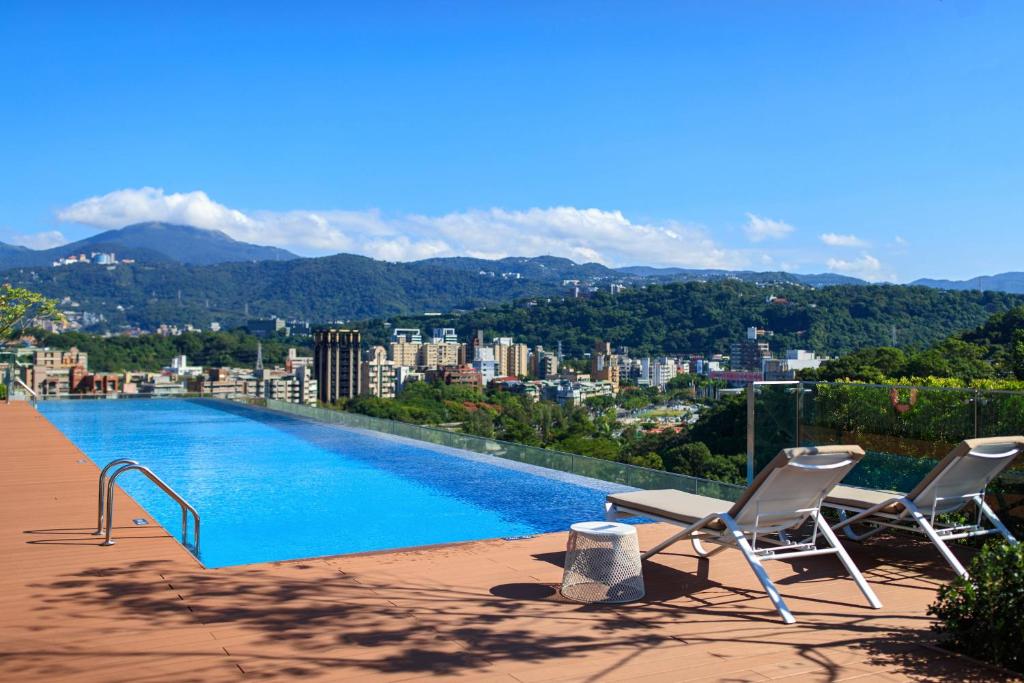 台北台北士林万丽酒店的一座带两把椅子的游泳池