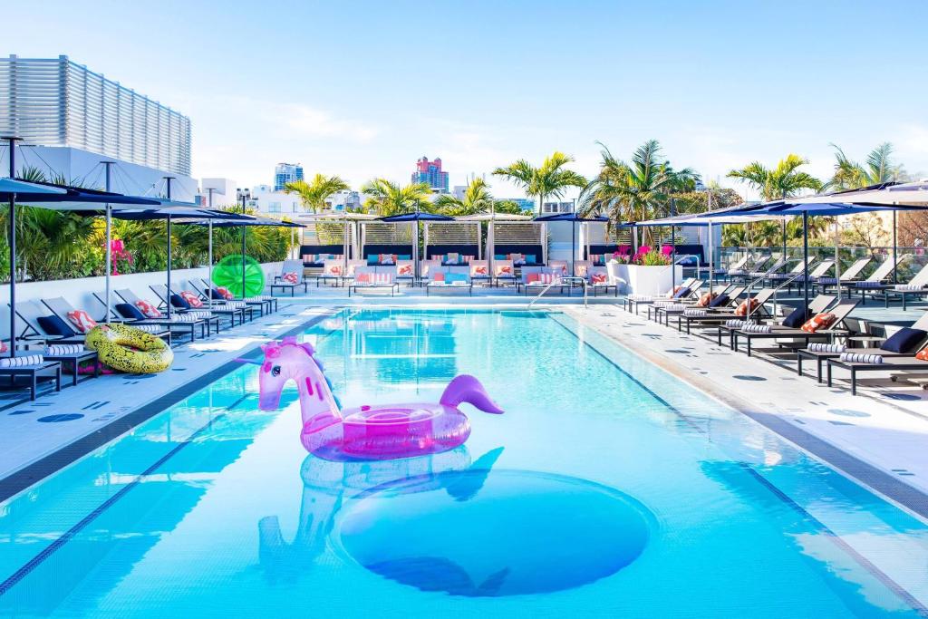 迈阿密海滩Moxy Miami South Beach的游泳池,水中有粉红色的鸭子