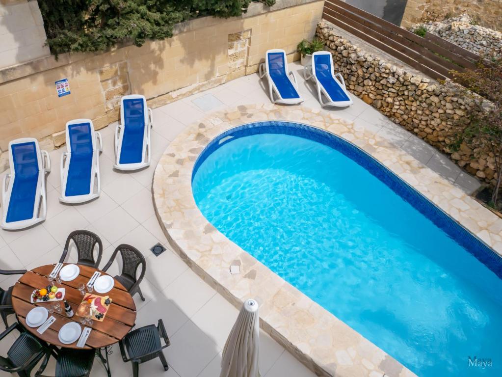 沙拉Il Gnejna的游泳池旁桌椅的顶部景色