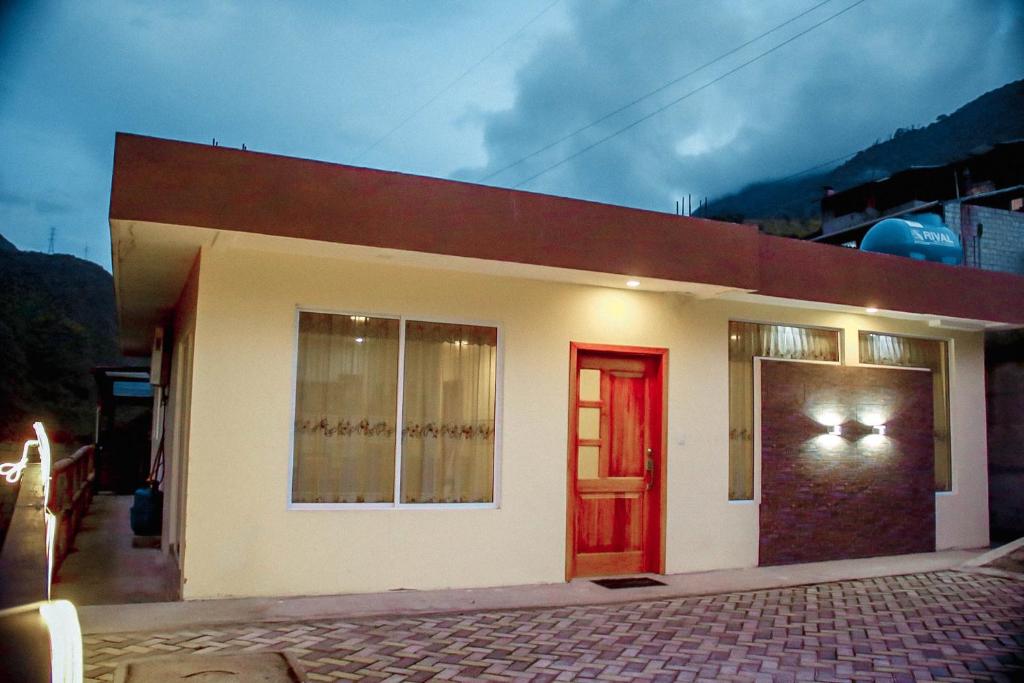 JuiviCasa de Campo - Baños de Agua Santa的一间设有红色门和窗户的小房子