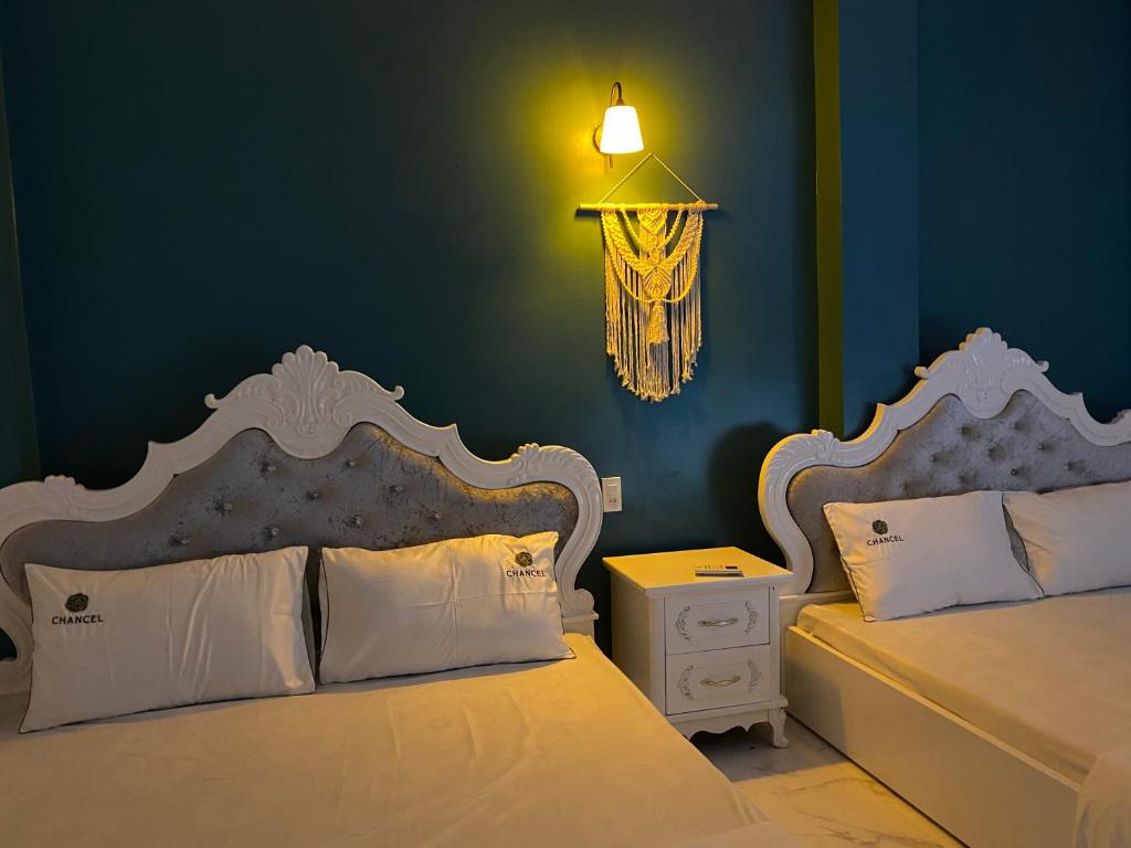吉婆岛吉婆岛圣托里尼民宿的一间卧室设有两张床和蓝色的墙壁