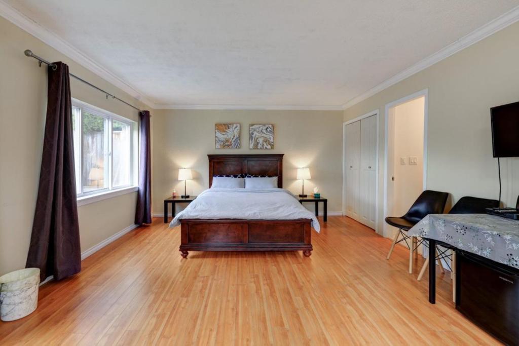 里士满Private Suite with Separated Entrance Monica's Home的一间卧室配有一张床,铺有木地板