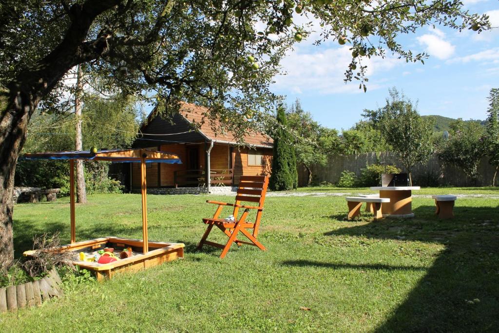 锡尔沃斯瓦里德Szilvásvárad Camping & Apartman的坐在树旁的院子中的椅子