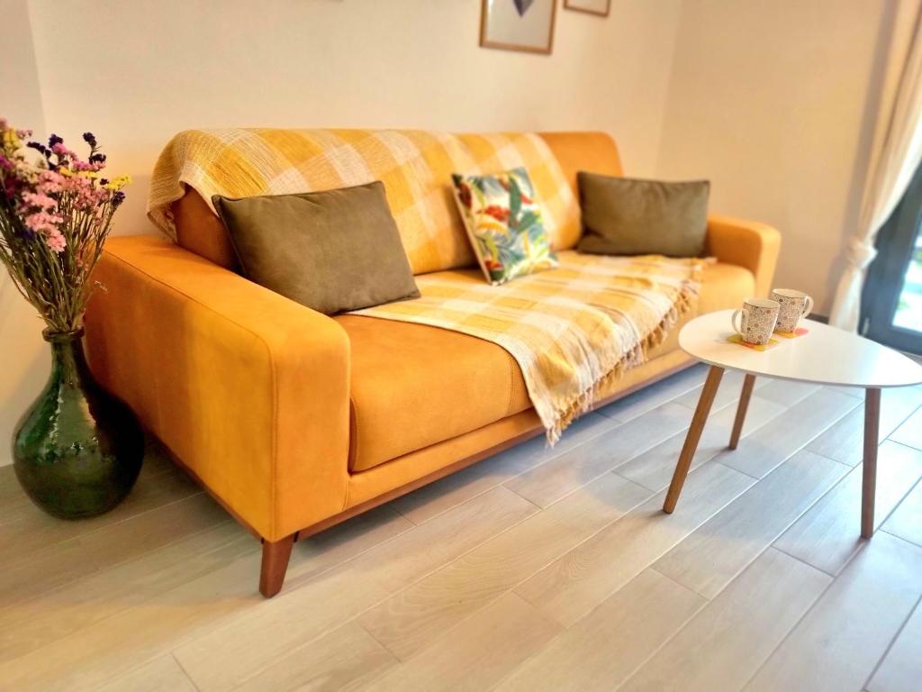 雅典Tiffany's apartments -2' walk from Metro的客厅里一张橙色的沙发,配有桌子