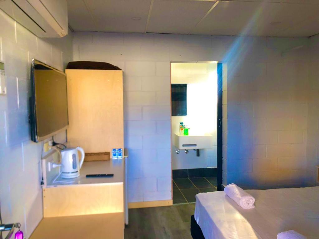 坎纳马拉OXFORD HOTEL MOTEL的小房间设有一张床和一间浴室