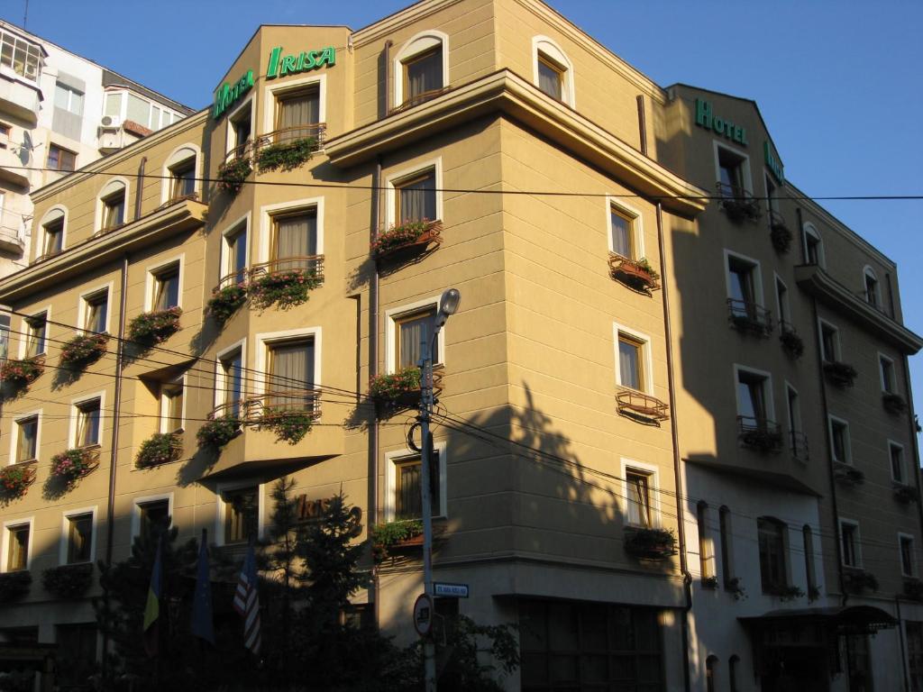 布加勒斯特艾里萨酒店的一座高大的建筑,旁边是植物