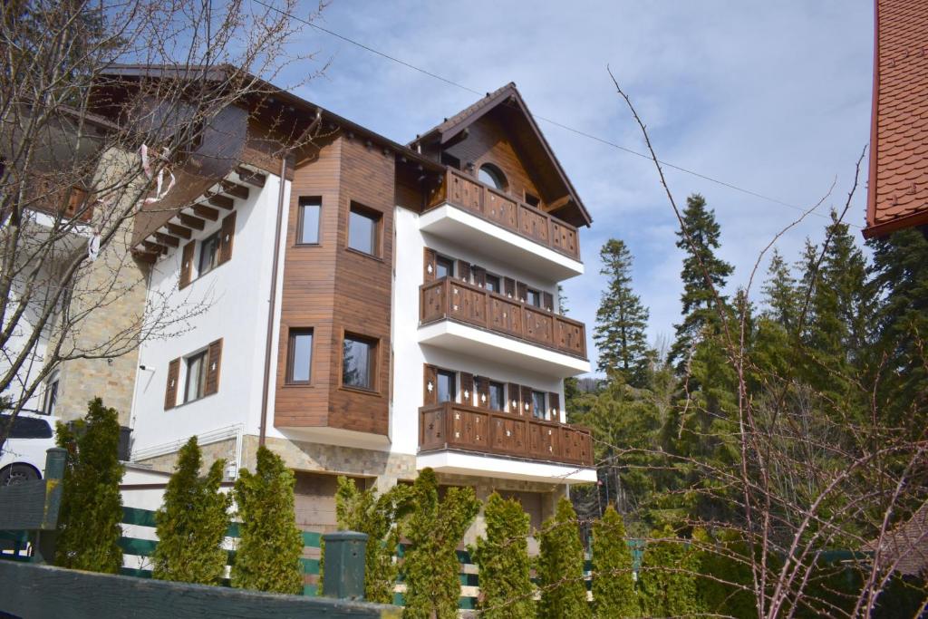 锡纳亚Cosy&Minimalistic Apartments - Haret Building的木阳台和树木的房子