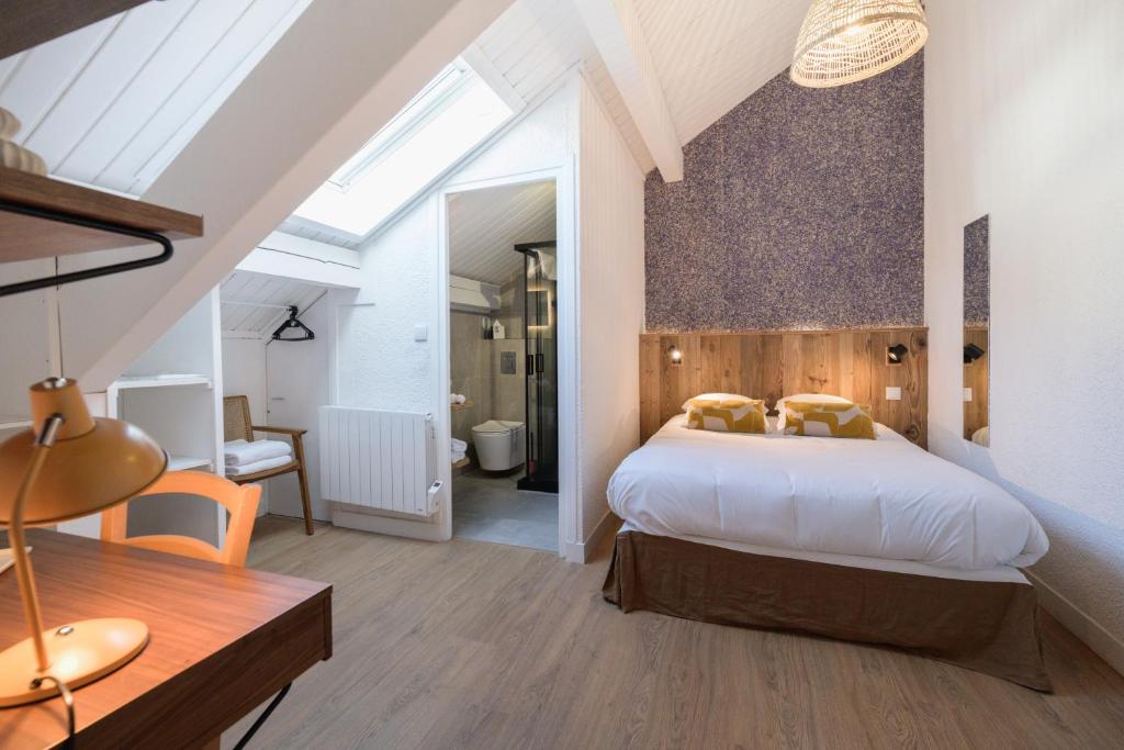 博福特Hôtel Maison Doron的一间带大床的卧室和一间浴室