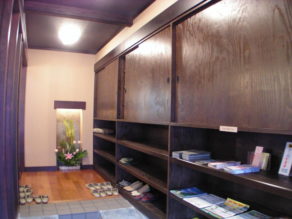 函馆辺见旅馆的一间设有木制橱柜的房间,配有鞋子和书籍