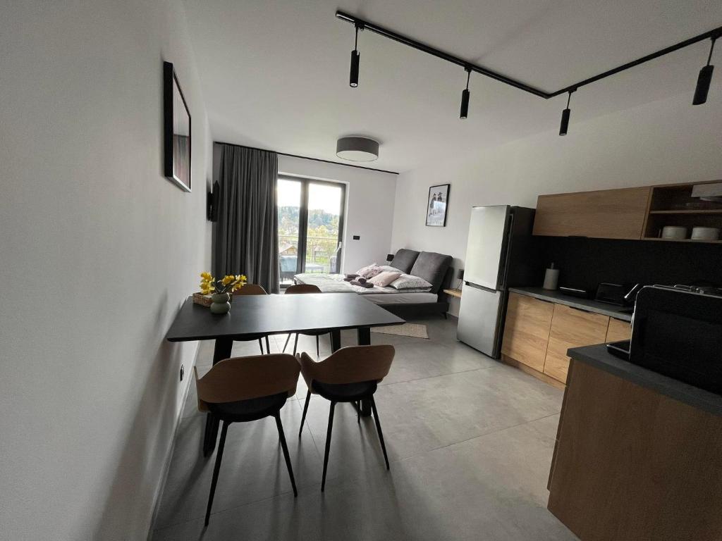 莱斯科Apartament w Dolinie Sanu的厨房以及带桌椅的起居室。