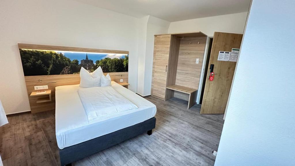 卡塞尔卡塞尔城市酒店的卧室设有白色的床和大窗户