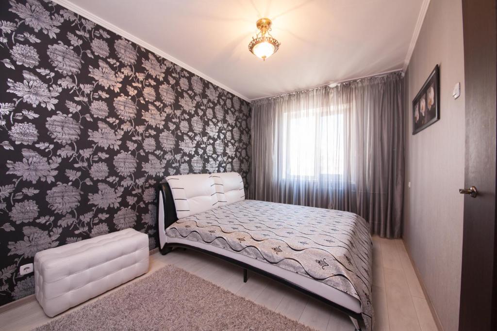 克拉斯诺亚尔斯克Apartment Baturina 19的一间卧室设有一张床和鲜花墙