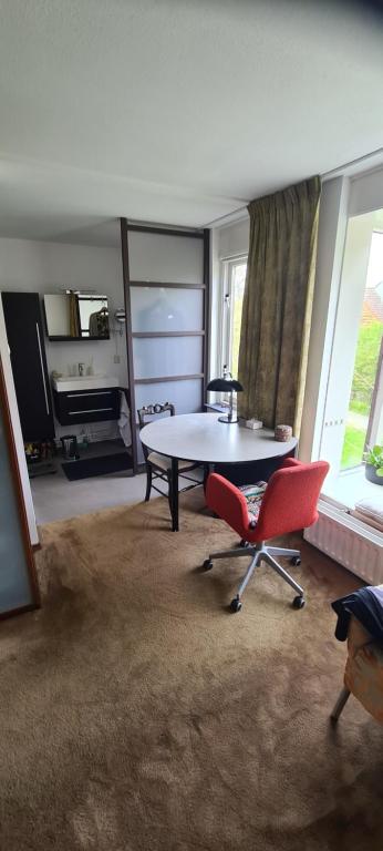尼沃海恩StudioRandijk的客厅配有桌子和两把椅子