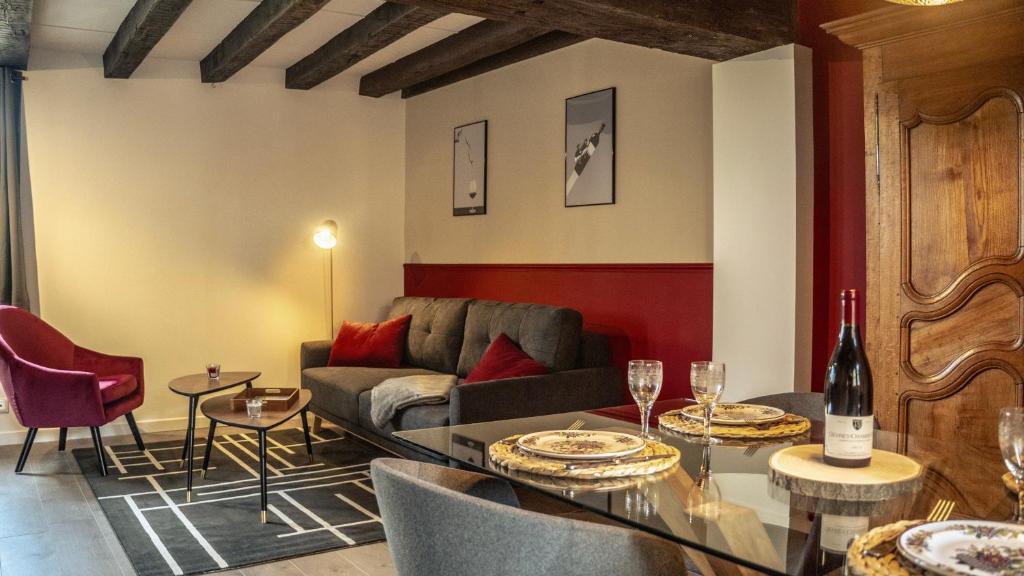 索恩河畔沙隆Le Sommelier Chalon的客厅配有沙发和带酒杯的桌子