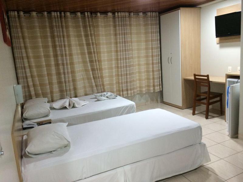 南克鲁兹罗Swamy Hotel的酒店客房设有两张床和一张桌子。