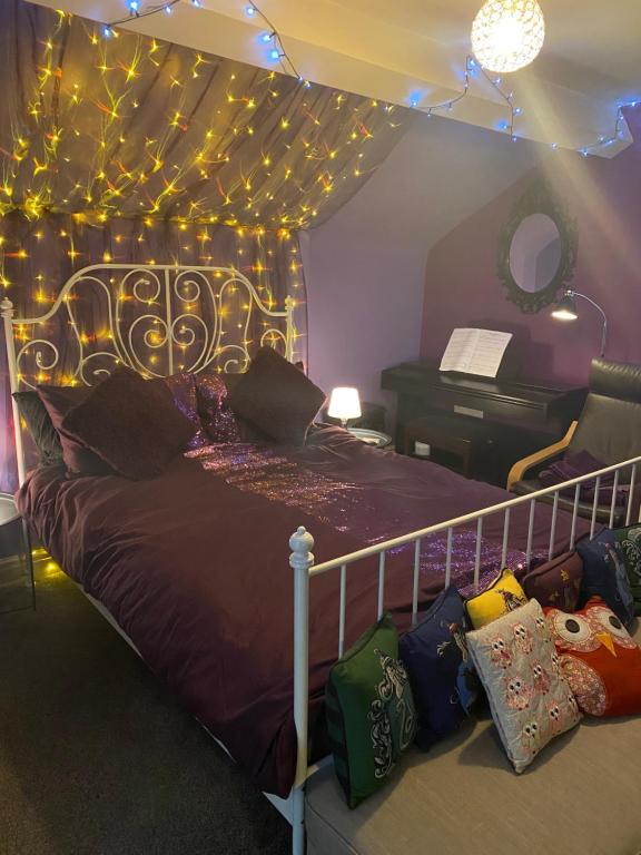 利物浦Tuebrook Towers的一间卧室配有一张带灯和钢琴的床