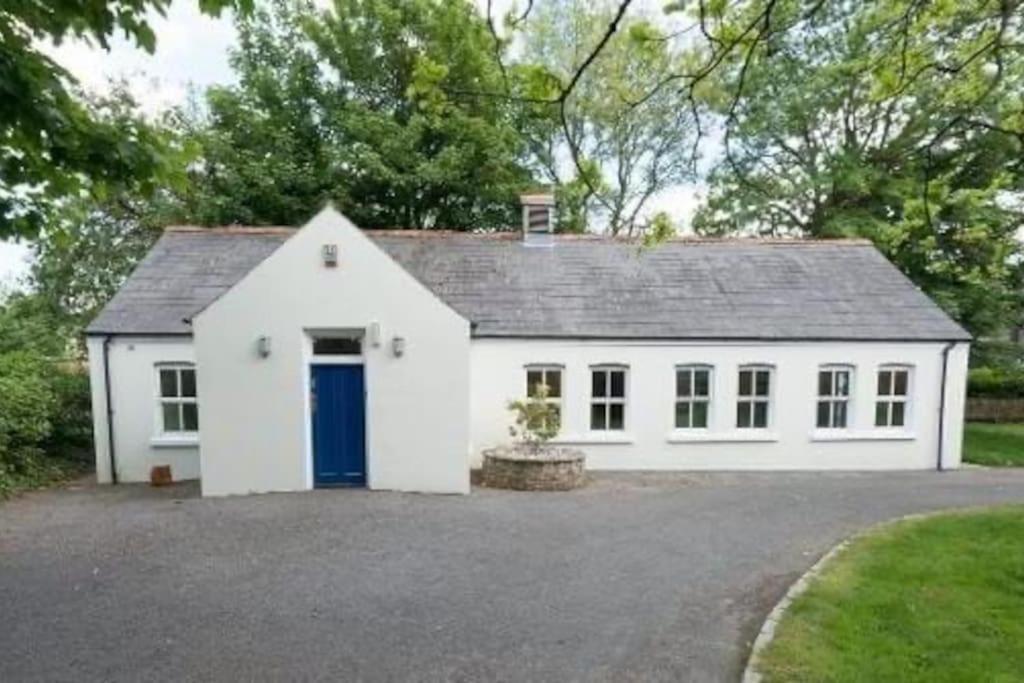 IrvinestownRose Cottage的车道上一扇蓝色门的白色房子
